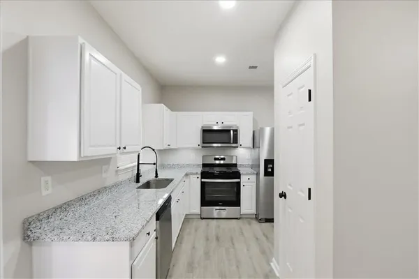 a kitchen with stainless steel appliances granite countertop a sink stove and cabinets