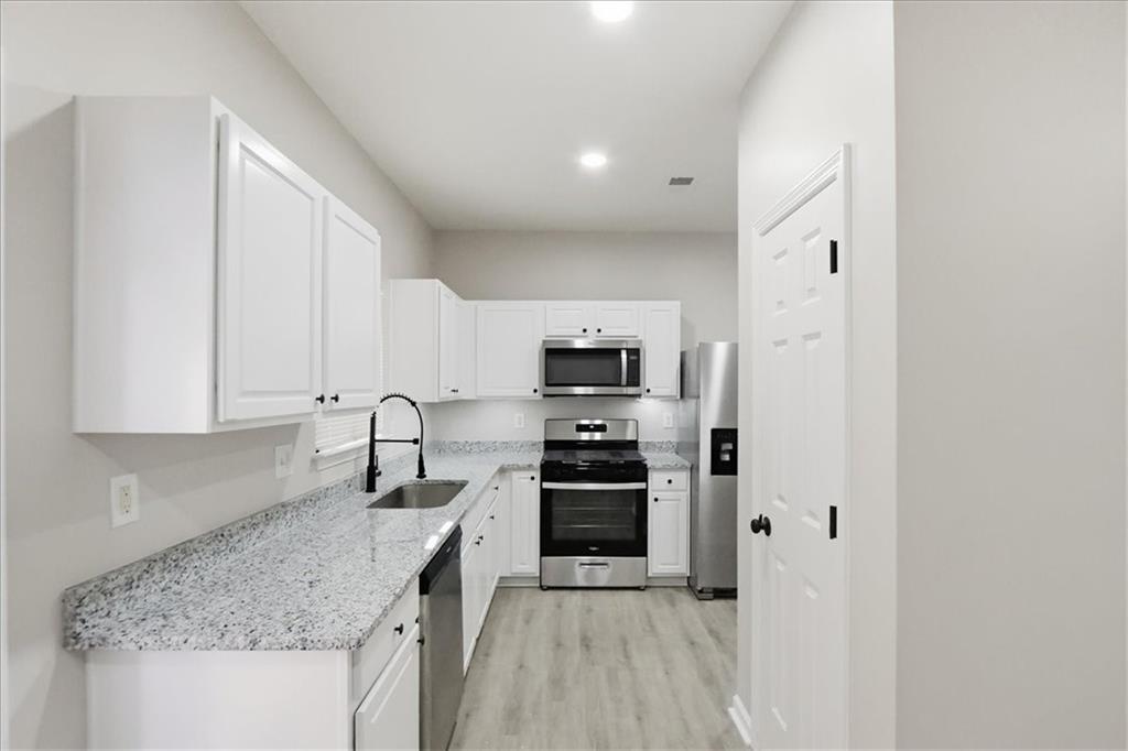 5630 Lawley Road Alpharetta, GA 30022 - Photo 20 of 65 a kitchen with stainless steel appliances granite countertop a sink stove and refrigerator