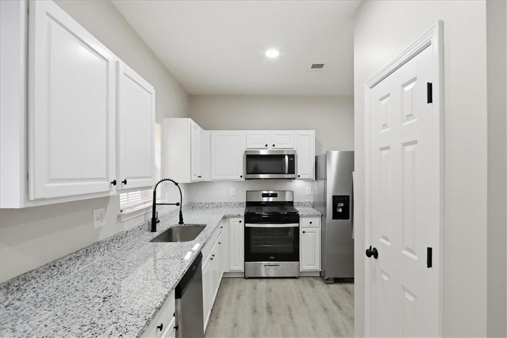 5630 Lawley Road Alpharetta, GA 30022 - Photo 21 of 65 a kitchen with stainless steel appliances granite countertop a stove a sink and a refrigerator