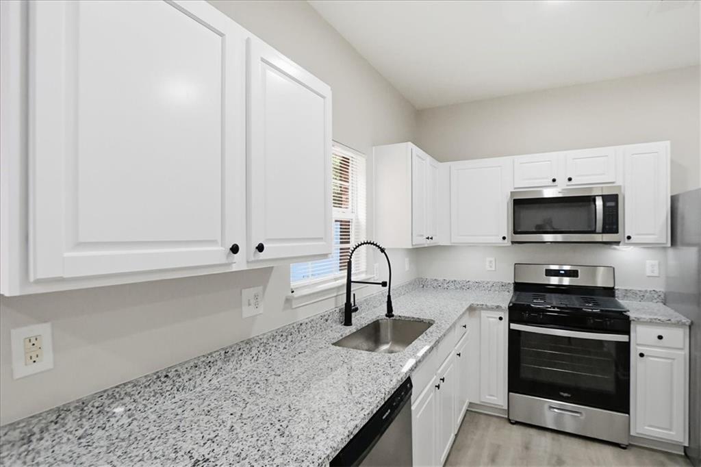 5630 Lawley Road Alpharetta, GA 30022 - Photo 23 of 65 a kitchen with stainless steel appliances granite countertop a sink stove and cabinets
