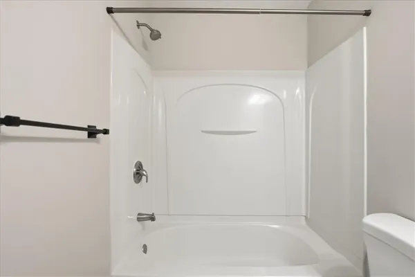a white bath tub sitting next to a white wall