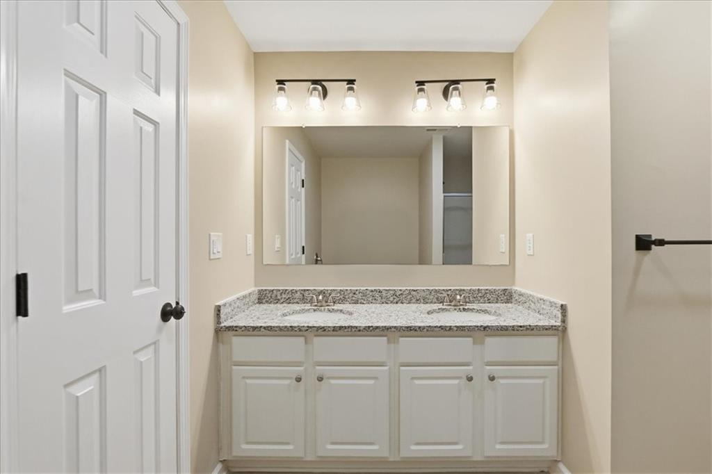 5630 Lawley Road Alpharetta, GA 30022 - Photo 45 of 65 a bathroom with a granite countertop vanity and a mirror