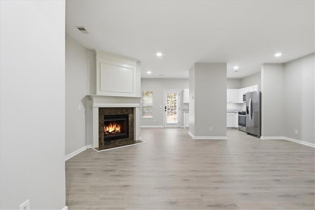 5630 Lawley Road Alpharetta, GA 30022 - Photo 9 of 65 a view of a kitchen with a fireplace a refrigerator and a fireplace