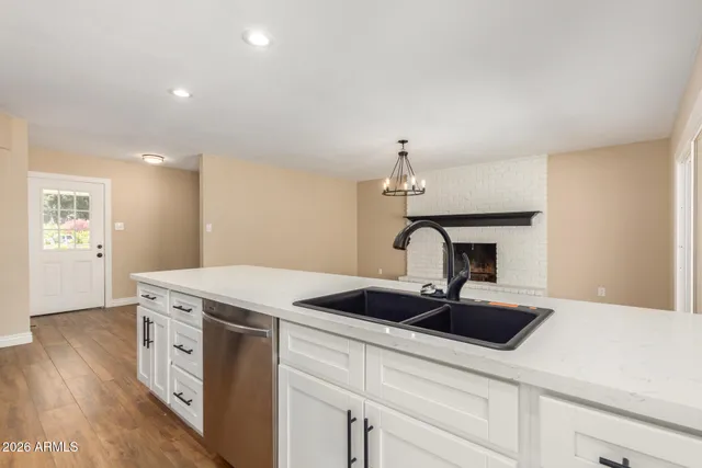 a kitchen with a sink and a stove with wooden floor