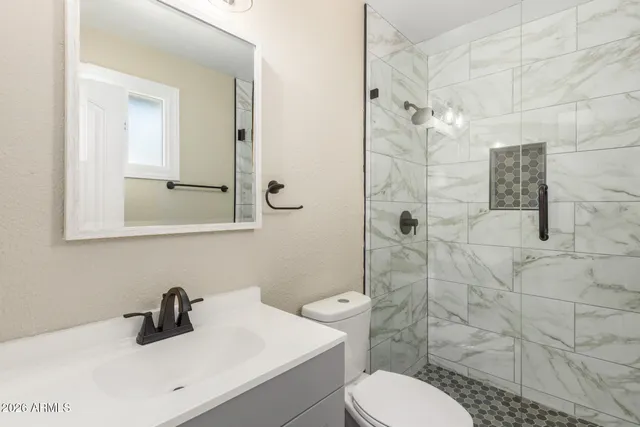 a bathroom with a sink toilet a mirror and shower