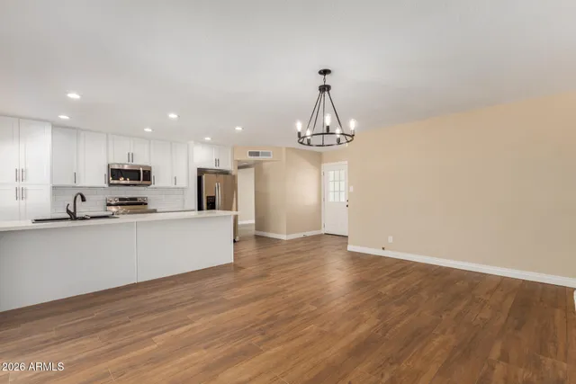 a view of a kitchen with sink and refrigerator