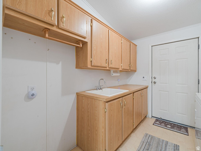 3941 West 40 North Hurricane, UT 84737 - Photo 32 of 55 Utility room featuring wood-finish cabinetry, a built-in sink with a countertop, and light-toned flooring