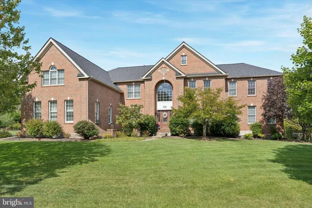 a front view of a house with a yard and trees