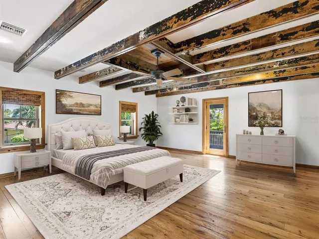 a spacious bedroom with a large bed and a wooden floor