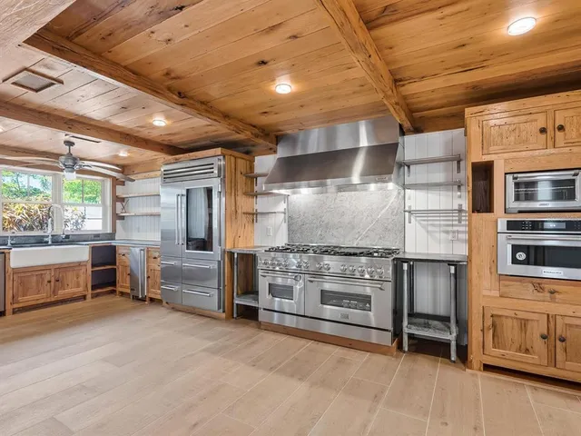 a kitchen with stainless steel appliances kitchen island granite countertop a stove and a refrigerator