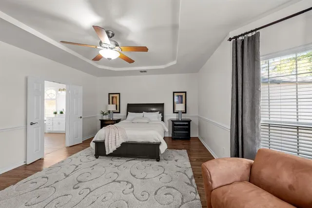 a bedroom with a large bed and a chandelier