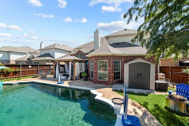 a swimming pool view with a seating space and a garden view