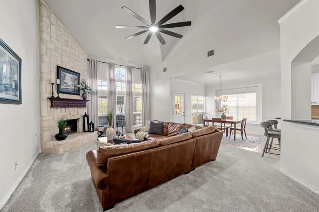 a living room with fireplace furniture and a large window