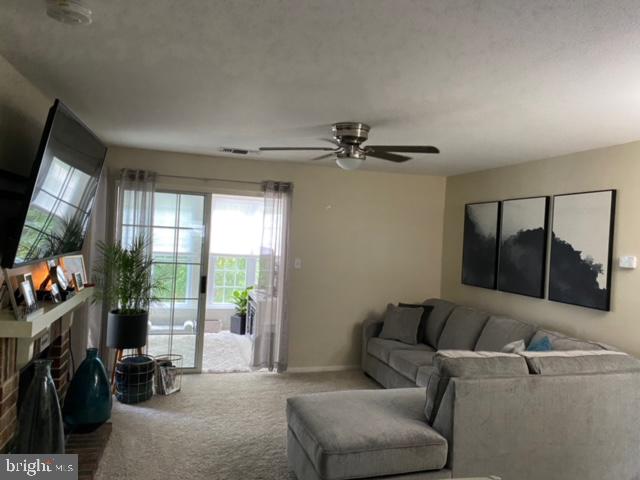602 Squire Lane, Unit D Bel Air, MD 21014 - Photo 16 of 28 a living room with furniture a flat screen tv and a floor to ceiling window