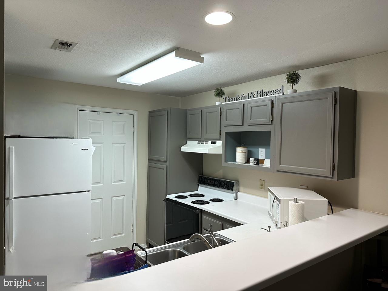 602 Squire Lane, Unit D Bel Air, MD 21014 - Photo 10 of 28 a kitchen with kitchen island a stove a refrigerator and a sink