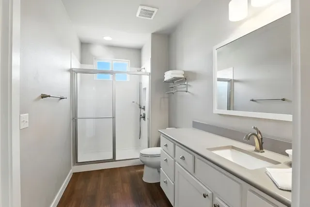 a bathroom with a granite countertop sink toilet and shower