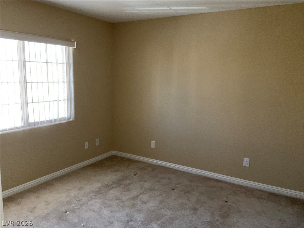 12 Jasmine Point Street Henderson, NV 89074 - Photo 6 of 15 A well-lit bedroom offering ample space and neutral tones, ready for personalization.