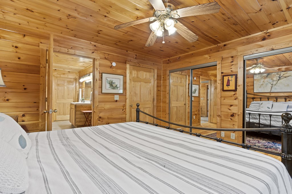96 Holiday Court Ellijay, GA 30540 - Photo 24 of 51 a bedroom with a large bed and a chandelier