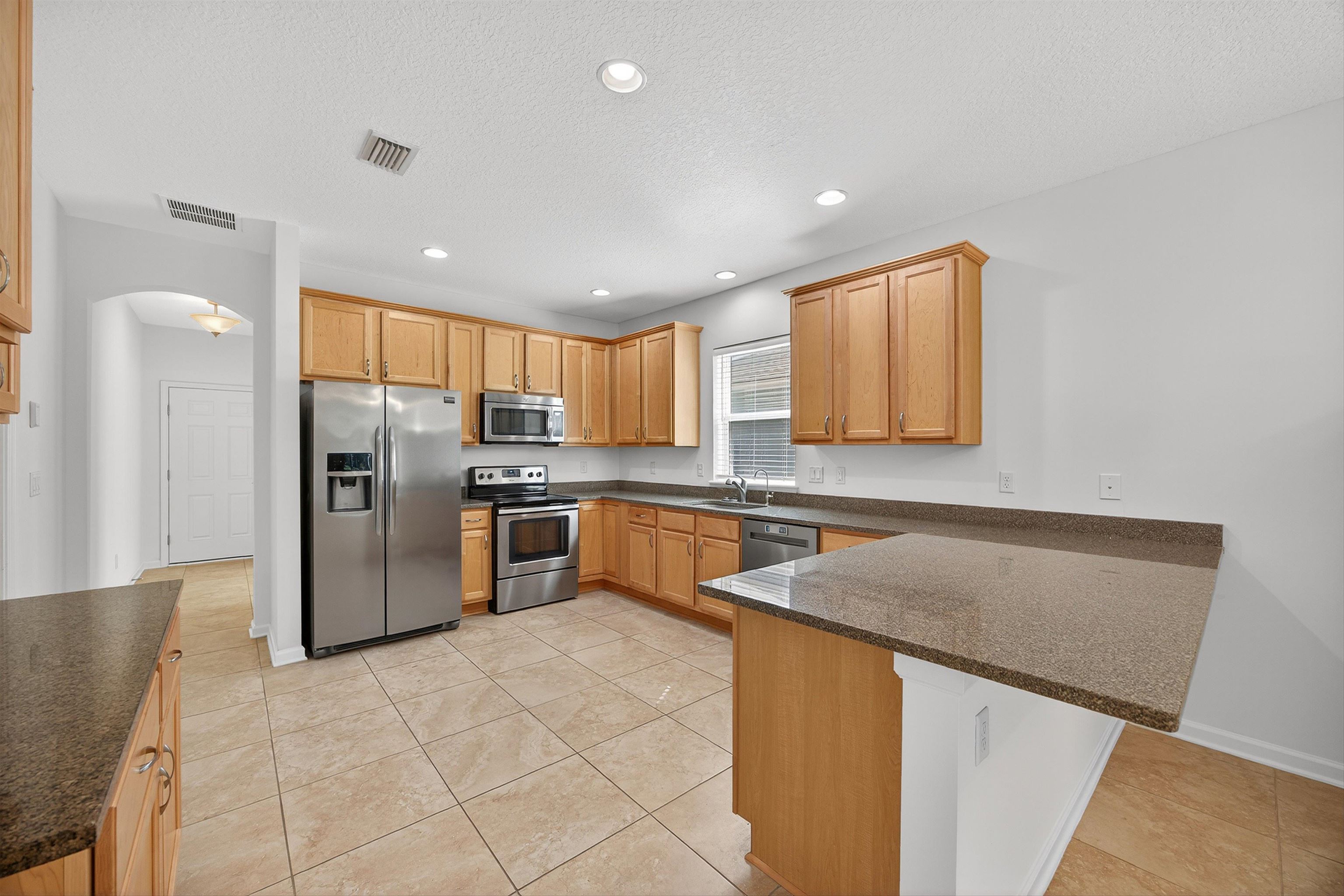 415 Balearics Drive St. Augustine, FL 32086 - Photo 11 of 30 a kitchen with stainless steel appliances granite countertop a refrigerator sink and microwave