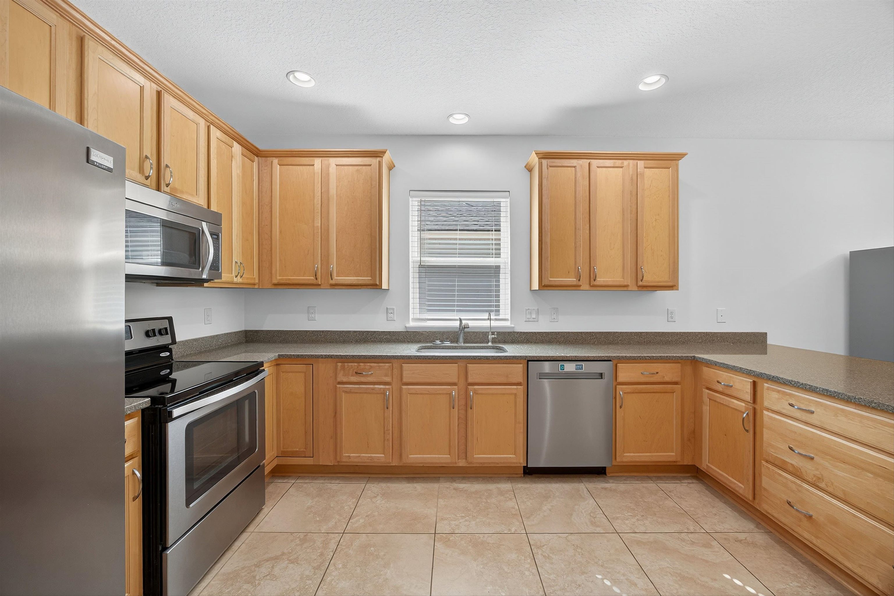 415 Balearics Drive St. Augustine, FL 32086 - Photo 12 of 30 a kitchen with stainless steel appliances granite countertop a sink and cabinets