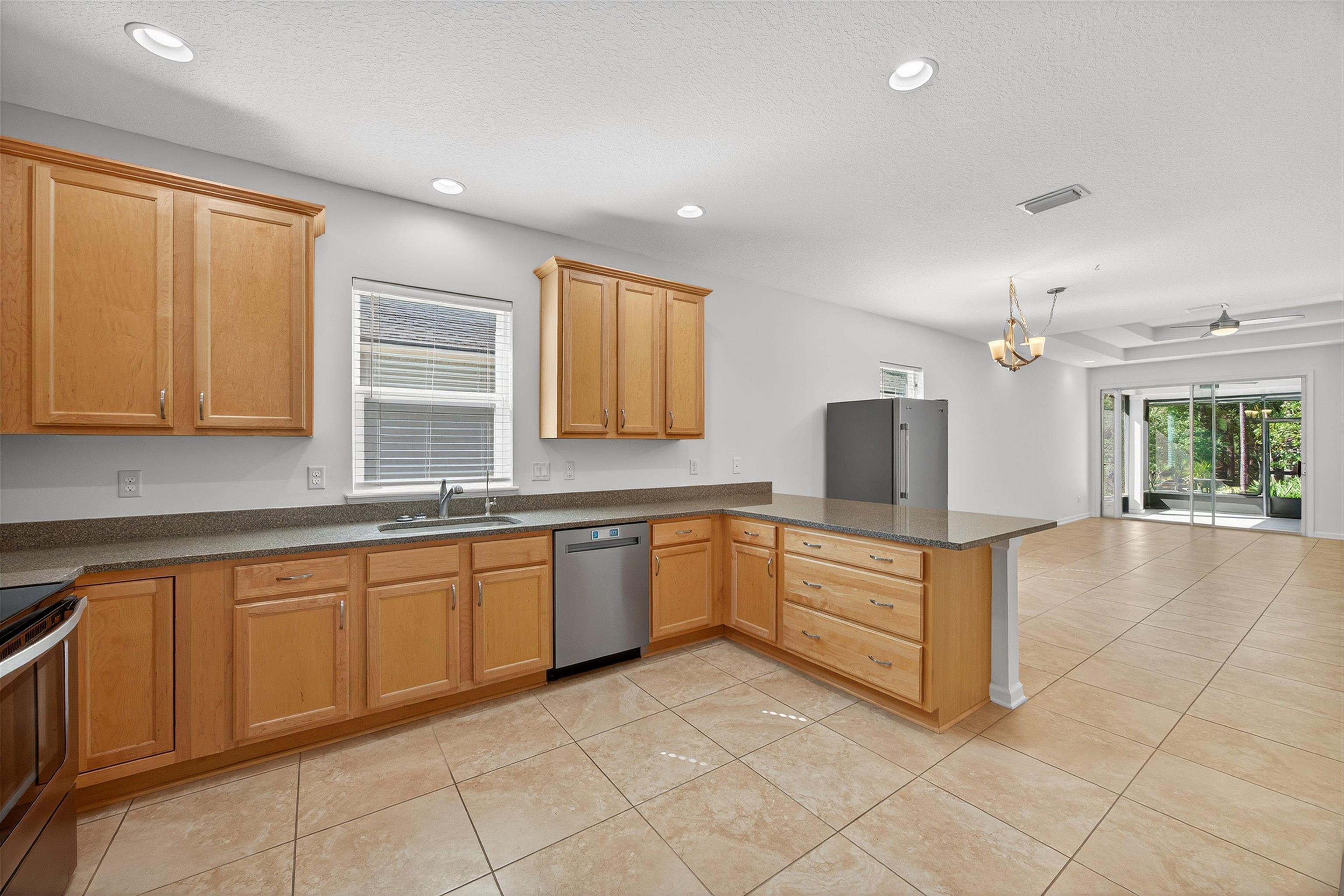 415 Balearics Drive St. Augustine, FL 32086 - Photo 30 of 30 a kitchen with granite countertop a sink white cabinets and stainless steel appliances