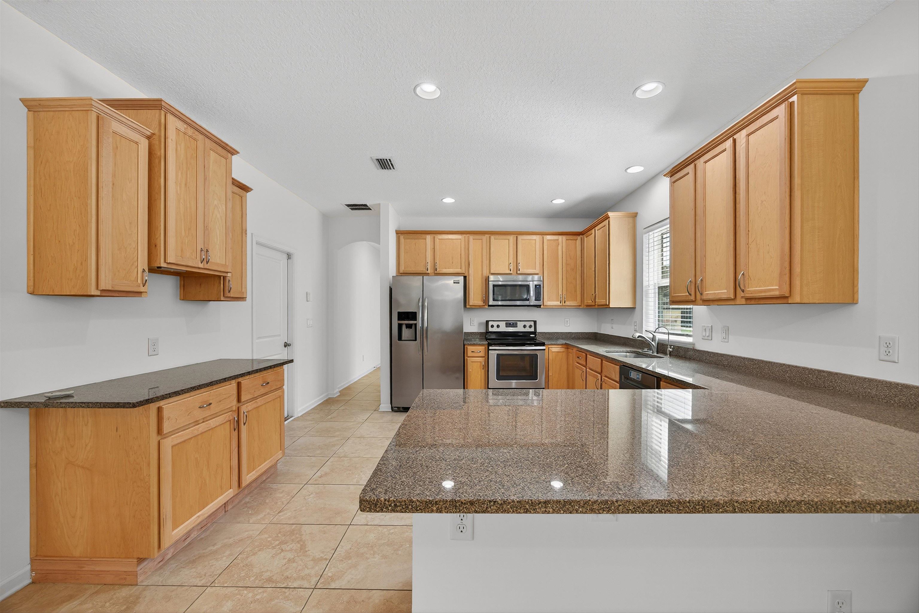 415 Balearics Drive St. Augustine, FL 32086 - Photo 13 of 30 a kitchen with stainless steel appliances granite countertop a sink a stove and a microwave