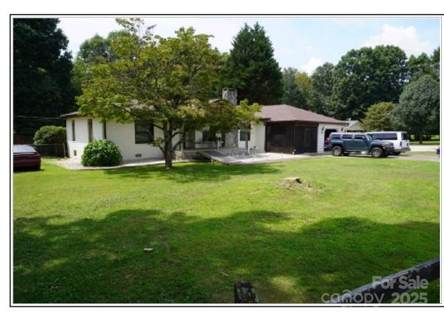 a white house with a big yard and large trees