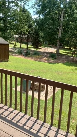 a view of a yard with wooden floor and fence