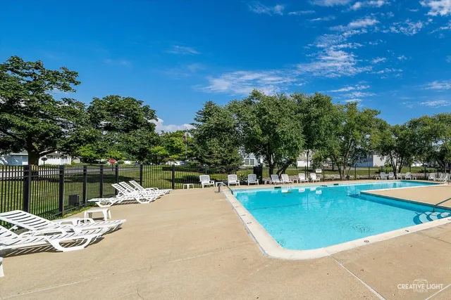 a swimming pool with outdoor seating and lake view