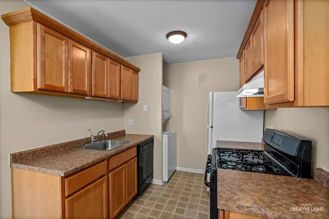 a kitchen with stainless steel appliances granite countertop a sink stove and cabinets