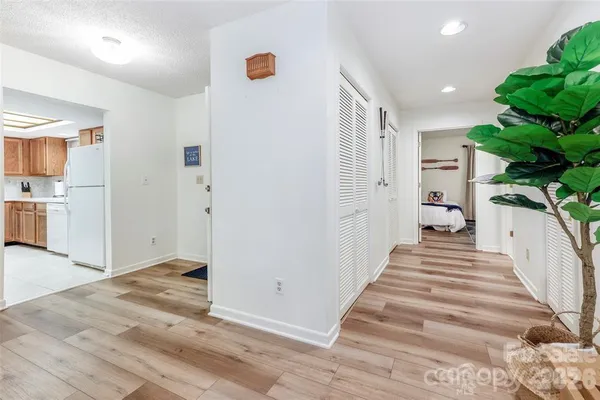 a view of a hallway with stairs and wooden floor