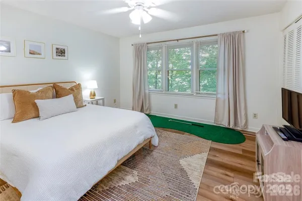 a bedroom with a bed a tv and a large window