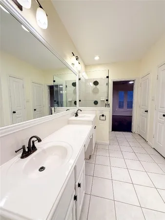 a large white room with a white tub shower and sink