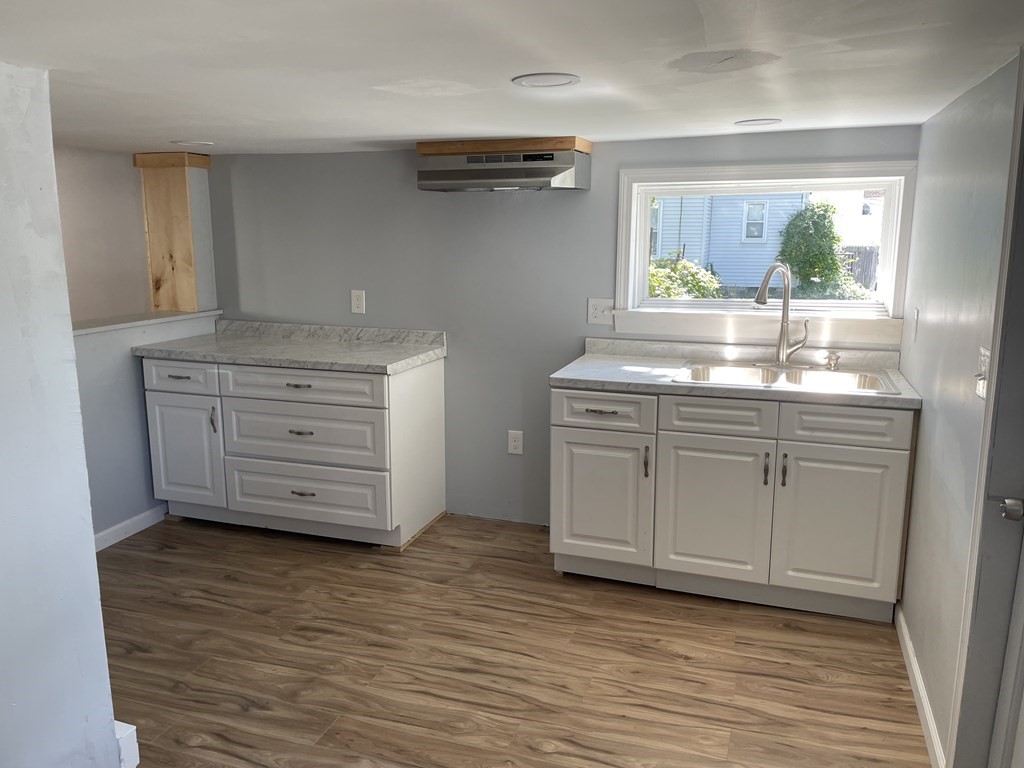 408 Nottingham Street Springfield, MA 01104 - Photo 4 of 12 a kitchen with stainless steel appliances granite countertop a sink and a wooden floor