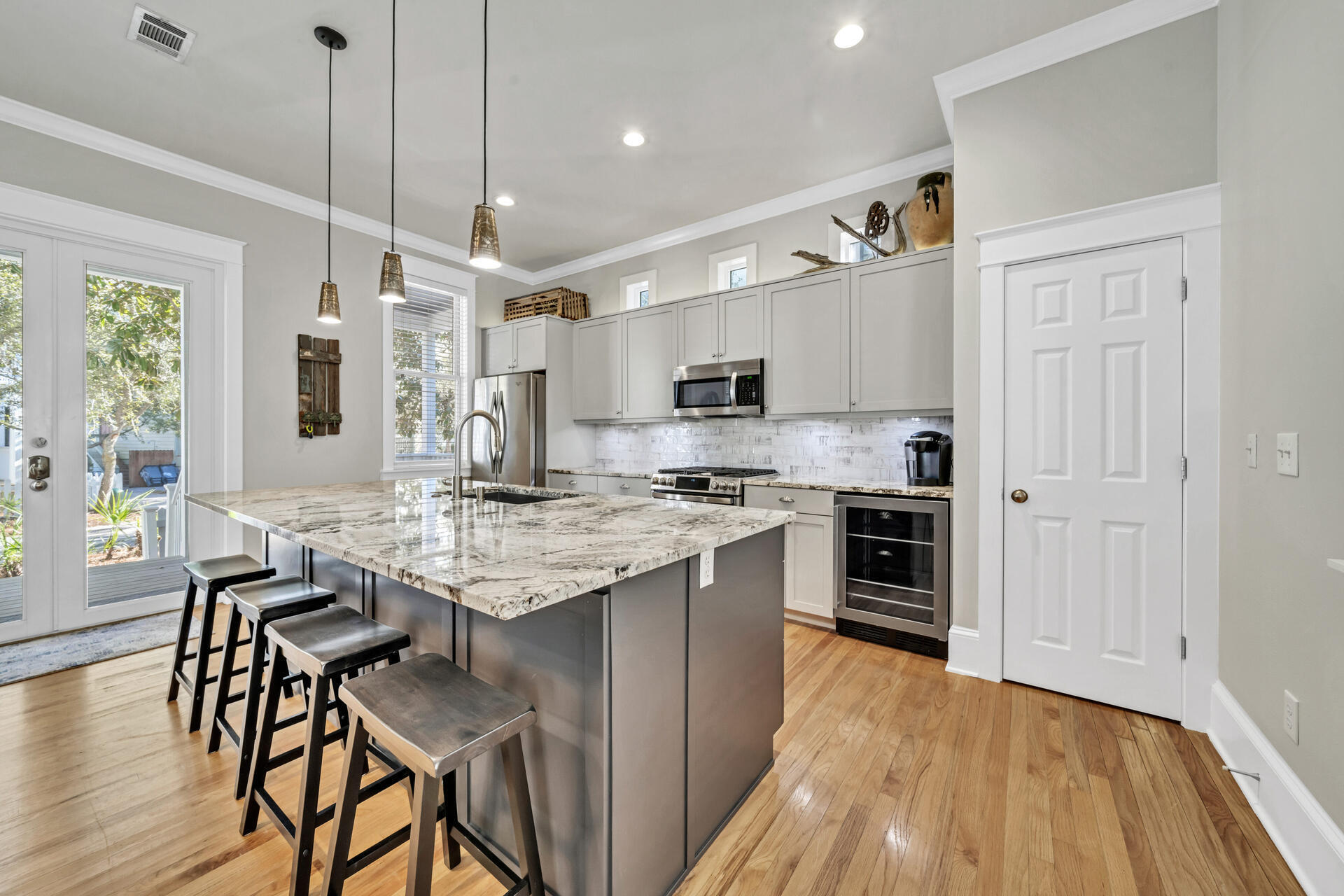 107 Chelsea Loop Road Santa Rosa Beach, FL 32459 - Photo 5 of 66 a kitchen with kitchen island granite countertop a stove a sink a dining table and chairs with wooden floor