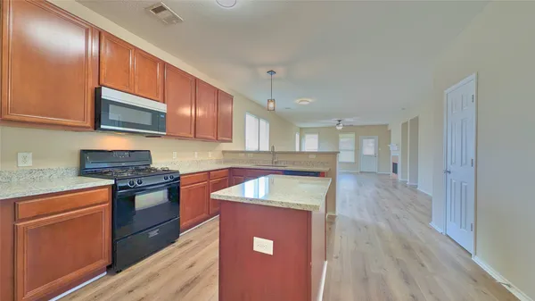 a kitchen with stainless steel appliances granite countertop wooden cabinets stove top oven and sink