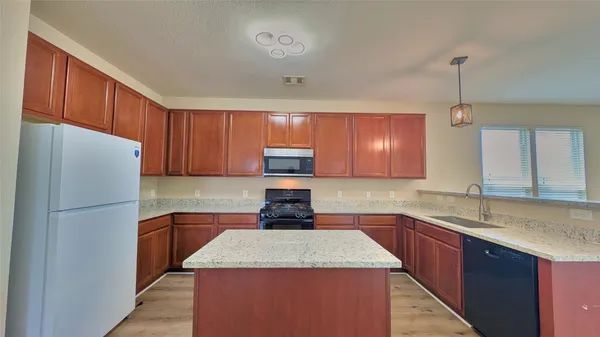 a kitchen with a sink a stove a refrigerator and cabinets
