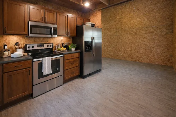a kitchen with stainless steel appliances granite countertop a stove a refrigerator and a microwave