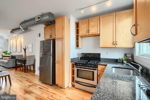 a kitchen with stainless steel appliances granite countertop a stove refrigerator and cabinets