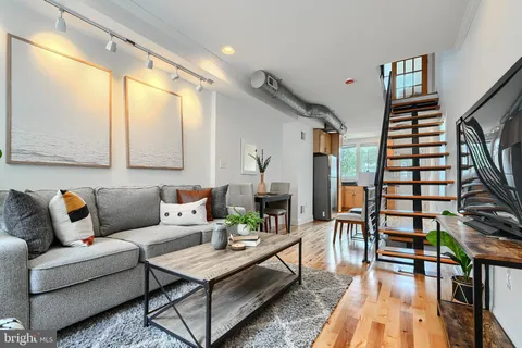 a living room with furniture and wooden floor