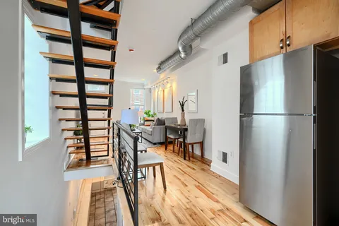 a view of a dining room with furniture a rug and wooden floor
