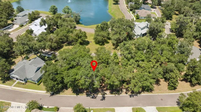 an aerial view of residential house with green space and trees all around