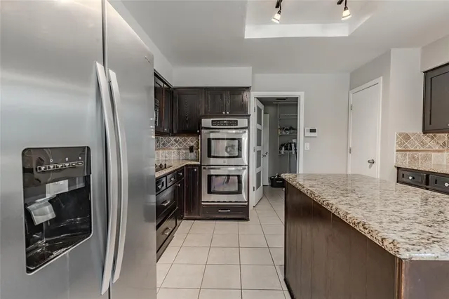 a kitchen with stainless steel appliances granite countertop a refrigerator and a sink