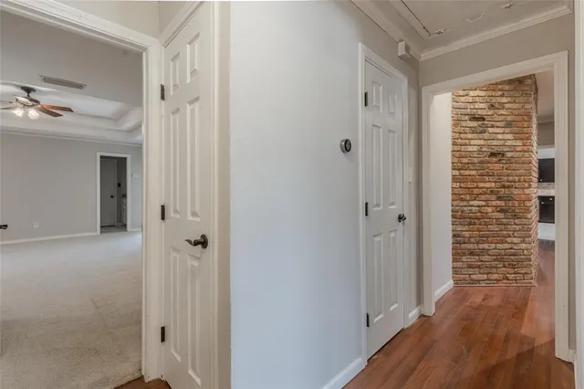 a view of a hallway with wooden floor and cabinet