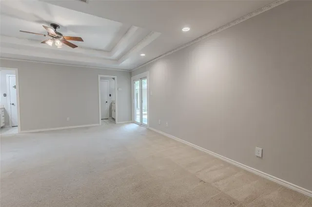 an empty room with windows and ceiling fan