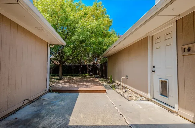 a backyard of a house with table and chairs