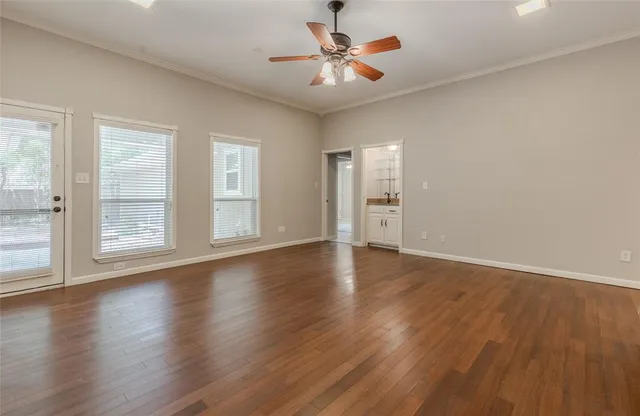 a view of an empty room with window and wooden floor