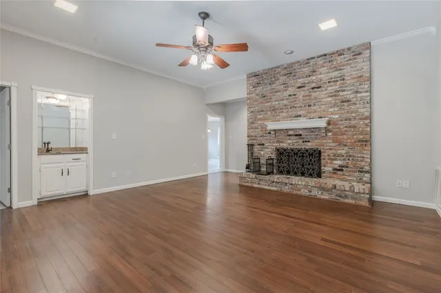 a view of empty room with wooden floor and fireplace
