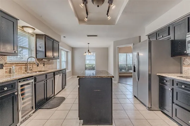 a large kitchen with a large counter top cabinets and stainless steel appliances