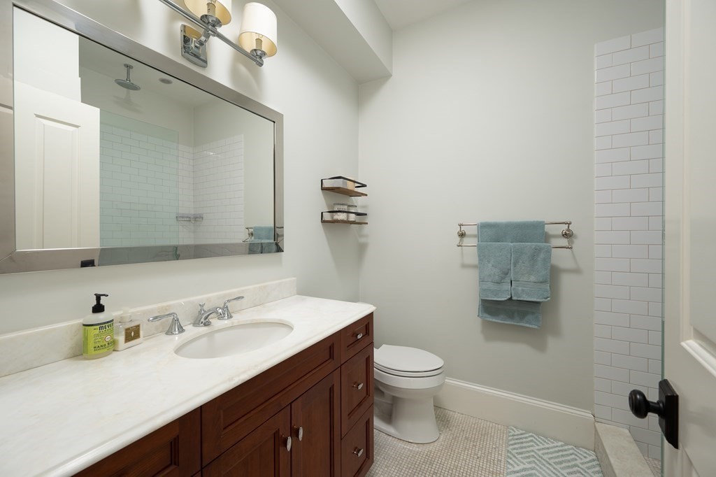 5 Dwight Street, Unit 1 Boston, MA 02118 - Photo 15 of 22 a bathroom with a granite countertop sink a toilet and a mirror